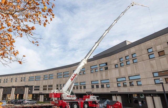 Crane lifts HVAC unit onto facility for maintenance